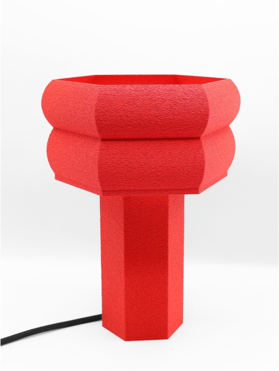 Lampe design Romy granit rouge, vue trois-quarts, volumes géométriques, ambiance minimaliste.