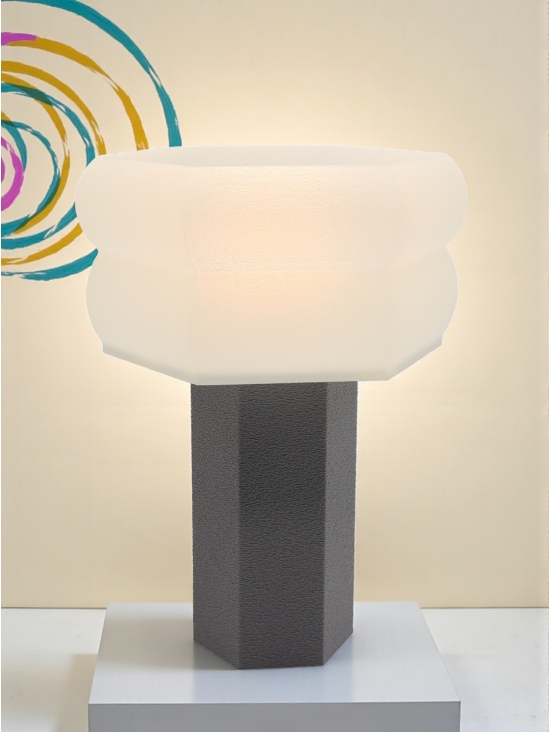 Lampe à poser Jacqueline Pop Essentiel grise allumée, abat-jour lumineux, ambiance douce avec motif spirale colorée vintage.