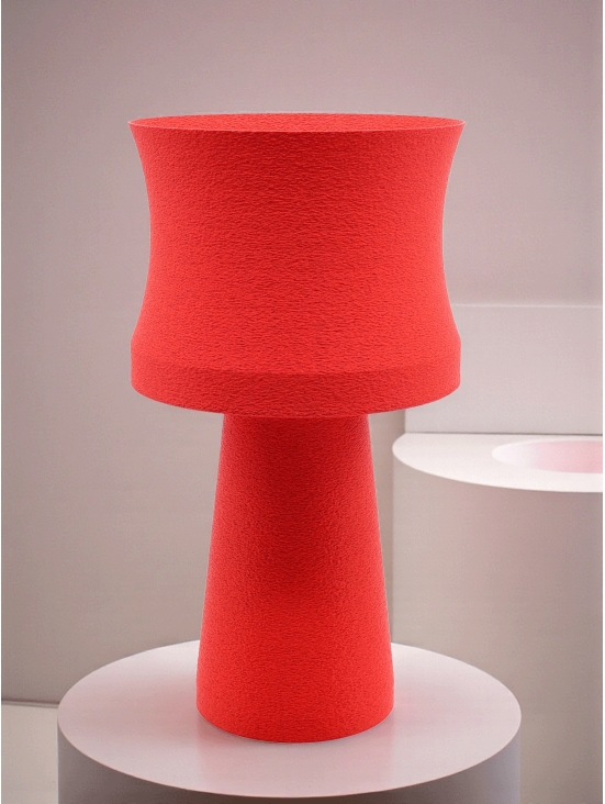 Lampe à poser design Agathe granit rouge sur socle rond blanc, ambiance douce et minimaliste, mur clair.