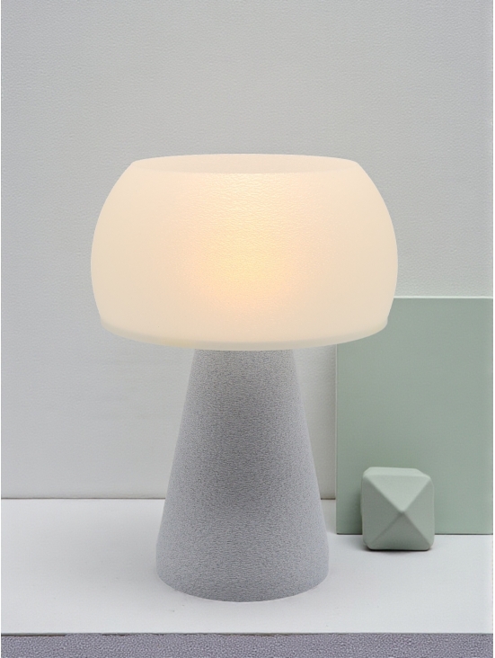 Lampe à poser design Annie granit pierre, lumière douce, ambiance minimaliste avec décor vert sauge.