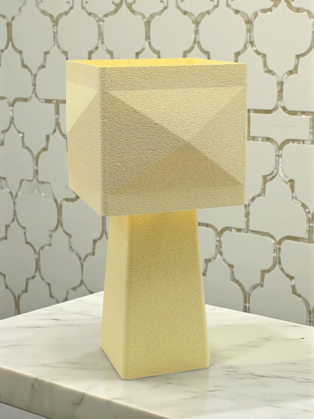 Lampe à poser design Léonie granit vanille, abat-jour carré, ambiance chic sur table marbrée et mur à motif.