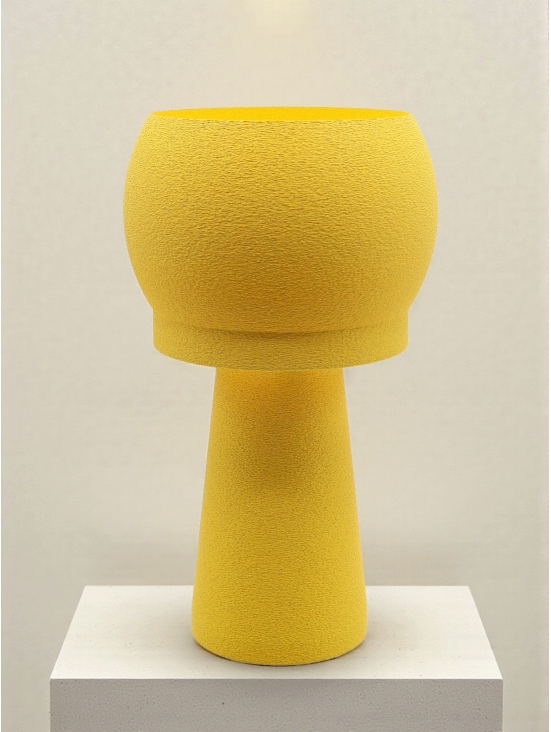 Lampe à poser design Noemie granit jaune, silhouette arrondie, ambiance studio lumineuse sur socle clair.