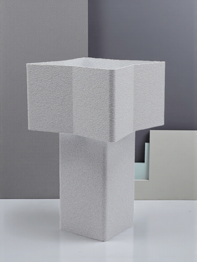 Lampe à poser design Odile granit pierre, forme géométrique, ambiance minimaliste sur fond gris graphique.