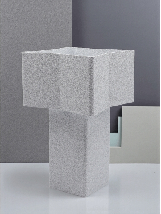 Lampe à poser design Odile granit pierre, forme géométrique, ambiance minimaliste sur fond gris graphique.