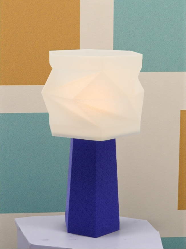 Lampe à poser Élise Pop Équilibre bleu péry allumée, abat-jour blanc facetté lumineux, ambiance graphique bleu et moutarde.