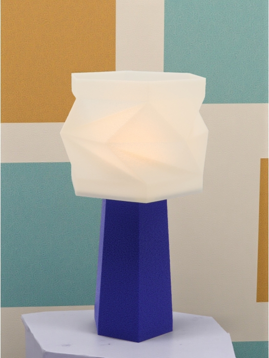 Lampe à poser Élise Pop Équilibre bleu péry allumée, abat-jour blanc facetté lumineux, ambiance graphique bleu et moutarde.